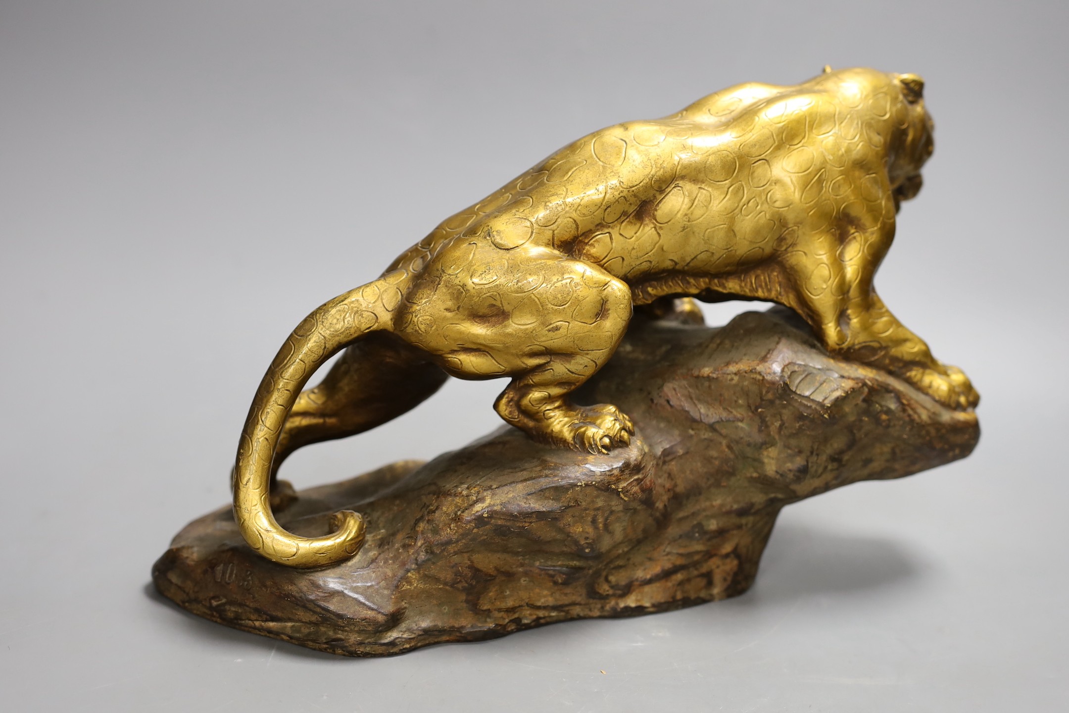 A gilt terracotta model of a panther on a rock, 21cms high